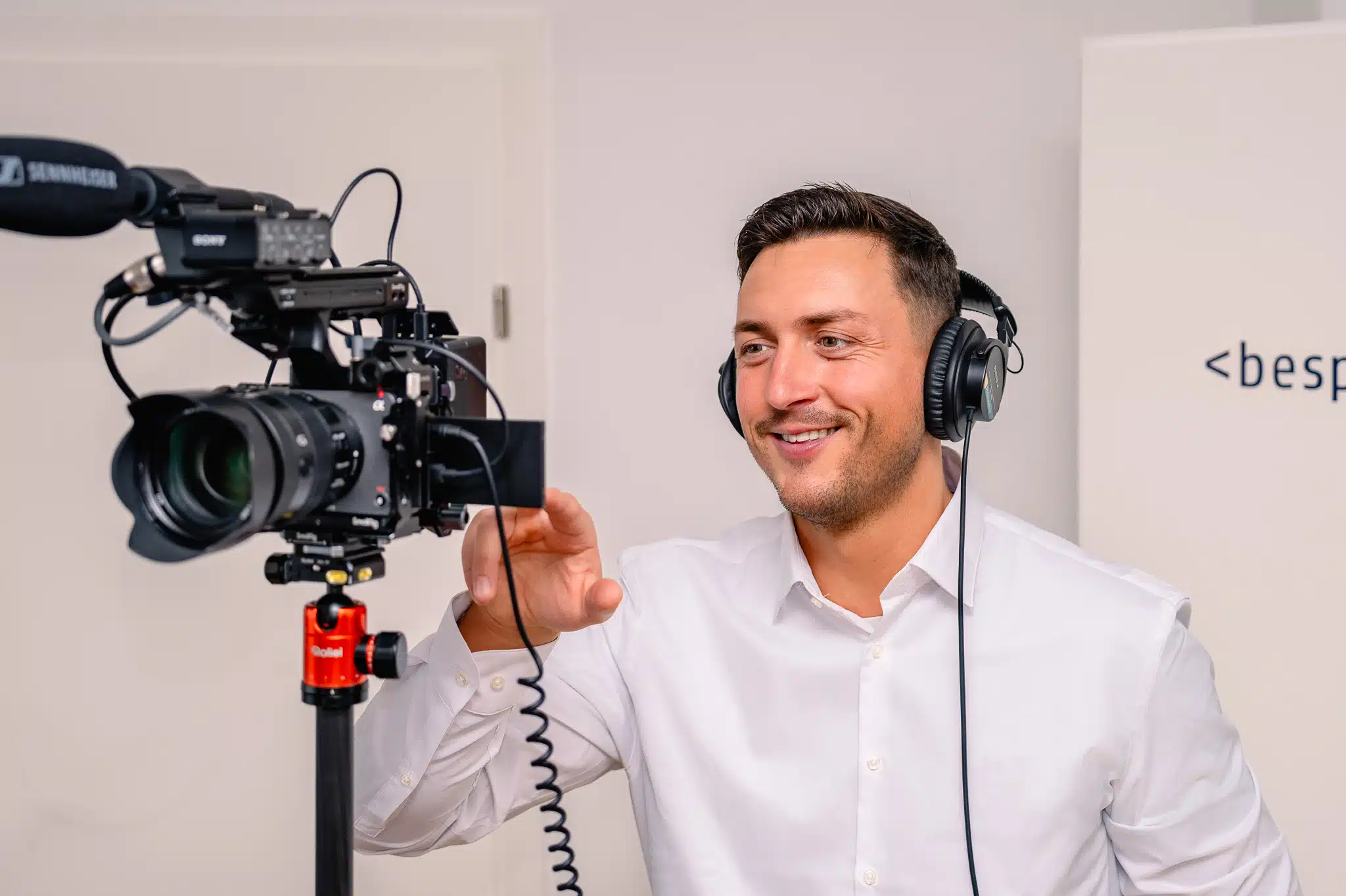 Person mit Kopfhörern bedient Kamera bei Filmproduktion.